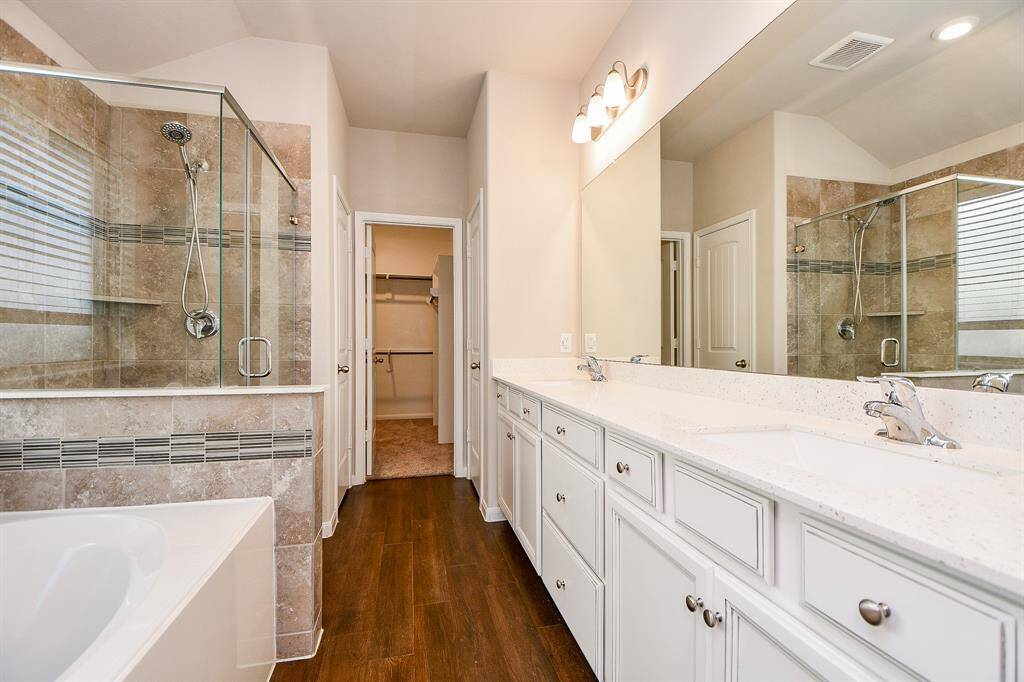 Indulge in the spacious elegance of this luxurious master bathroom, featuring exquisite finishes.