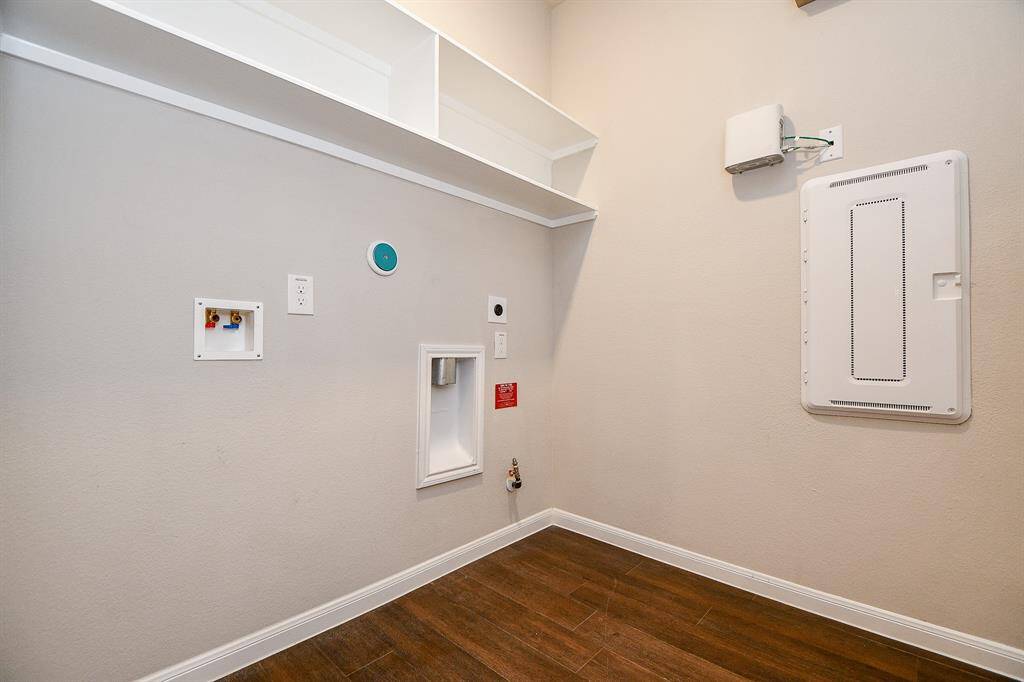 Streamlined utility room with built-in shelving and essential hookups.