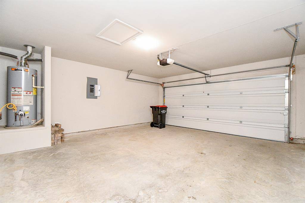 Spacious, finished garage equipped with a convenient door opener and a hot water heater.