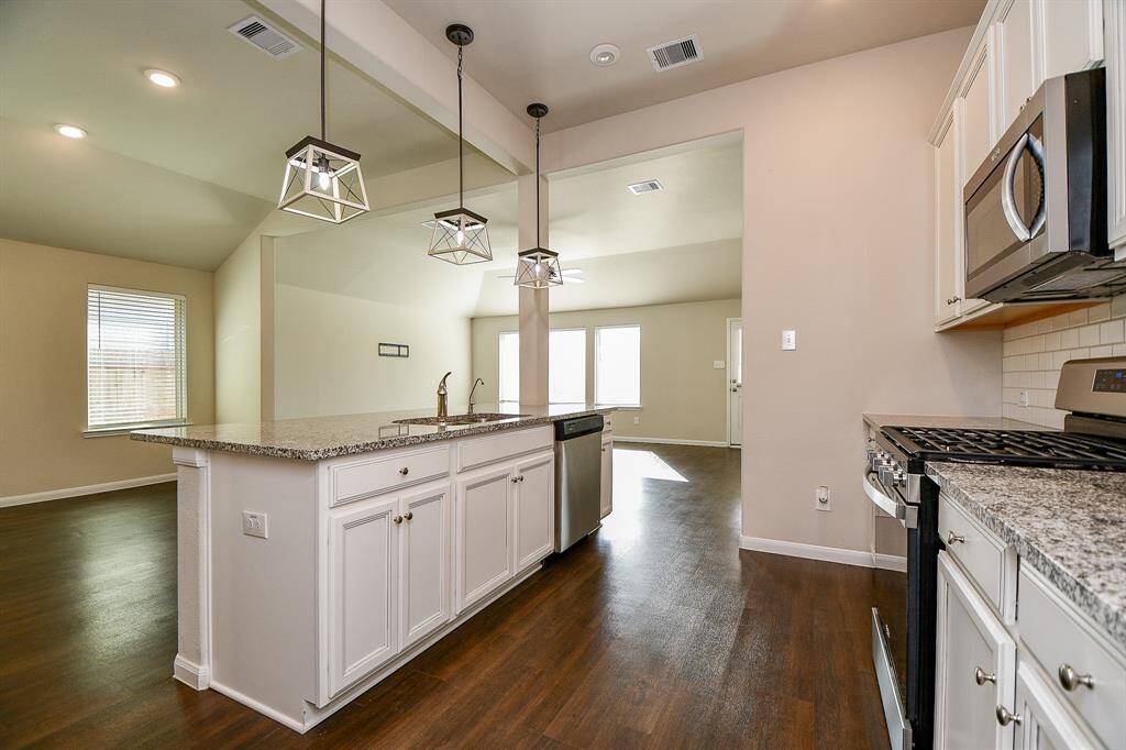 Expansive kitchen with abundant cabinetry and generous countertops.
