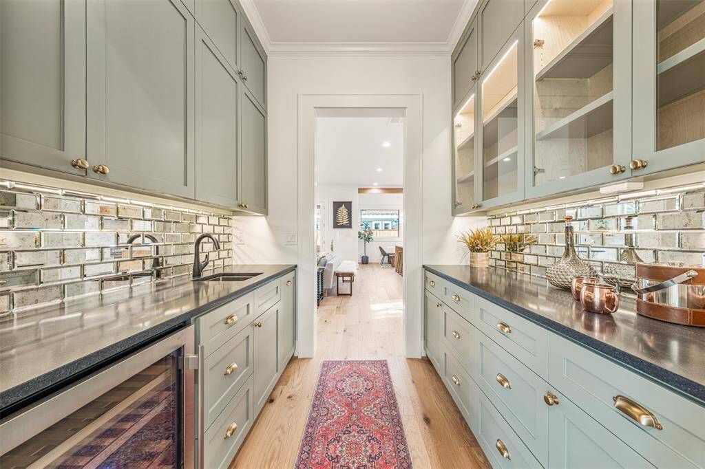 The butler’s pantry is both fun and functional, featuring a sophisticated backsplash, brass details, and a seamless flow into the rest of the home.