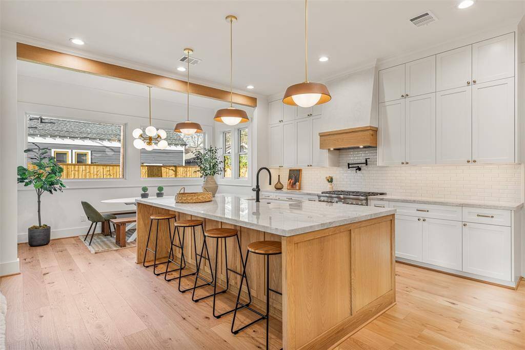 The heart of the home! This gourmet kitchen features stunning white oak cabinetry, perfectly curated light fixtures, and a thoughtful layout for everyday living and entertaining.