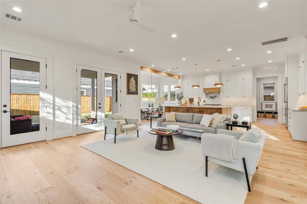 Designed for both comfort and effortless entertaining, this living room seamlessly connects to the outdoor retreat with elegant French doors and an additional access point to the backyard.
