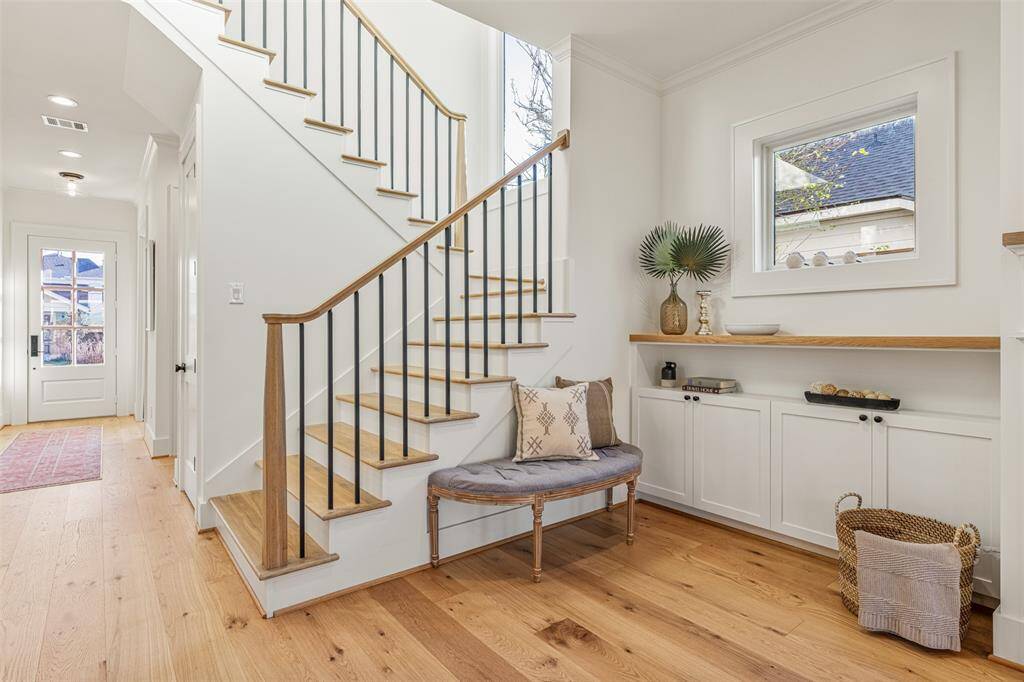 A breathtaking staircase with large windows on the landing, allowing natural light to pour in and enhance the home's airy feel.