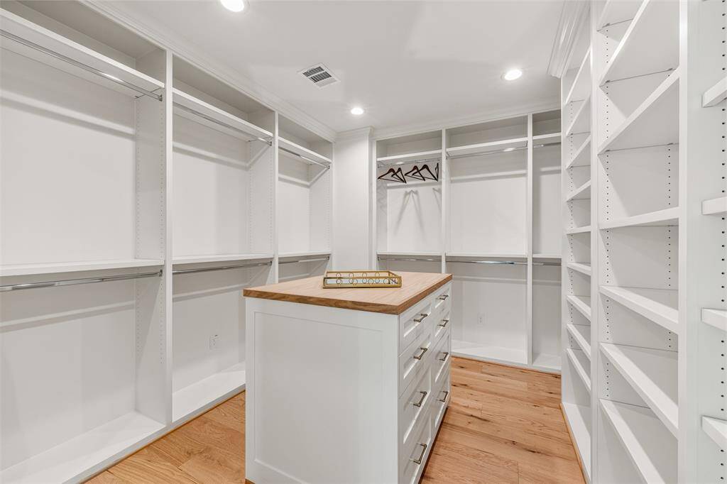 A luxurious and spacious primary closet, complete with custom built-ins for effortless organization.
