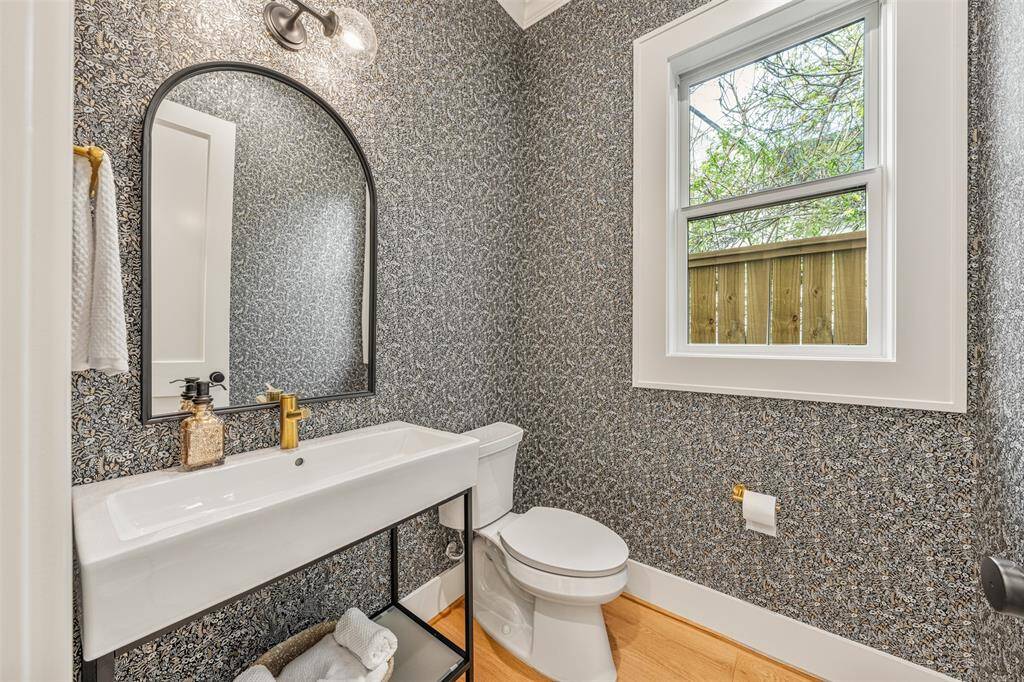 The powder room is a true gem, featuring elegant details, eye-catching wallpaper, and sophisticated finishes.
