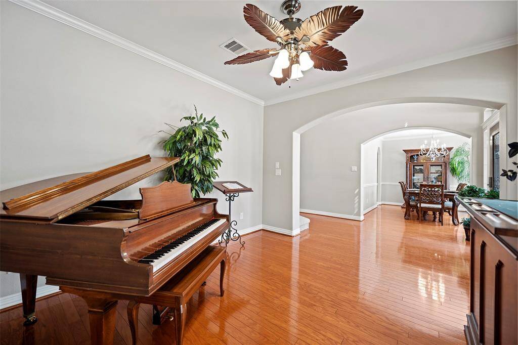 We just love the look of this space with the wood floors, crown molding, crisp paint tones and touch of fun with the palm ceiling fan.  Reminds us of a swanky music parlor!