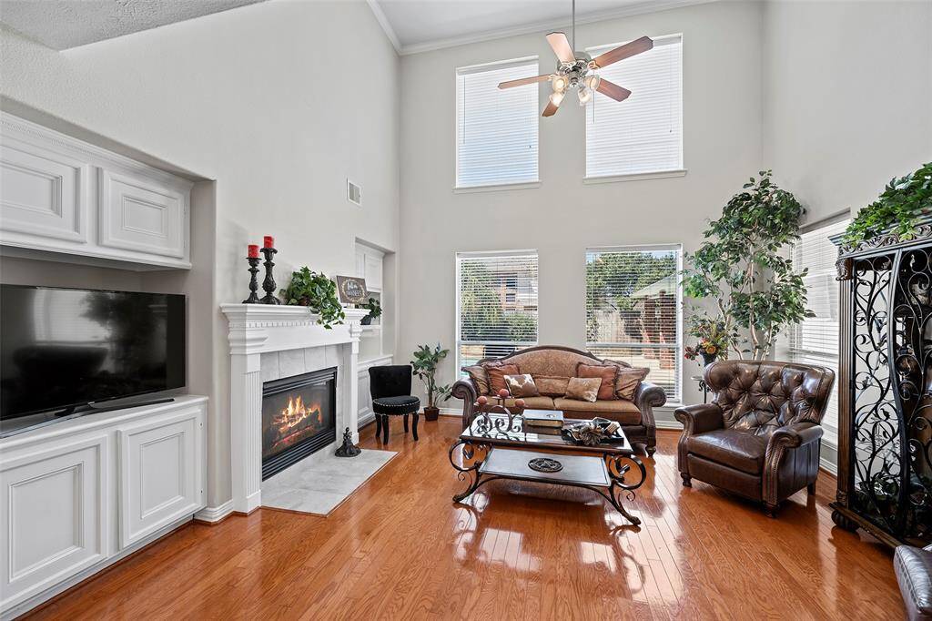 This 2-story family room is light and bright and offers a wall of windows with views of the outdoors, more of the classic crown molding, custom built-ins flanking the gas log fireplace!  That custom wood mantel is the perfect size for placing artwork or displaying your favorite decor pieces!