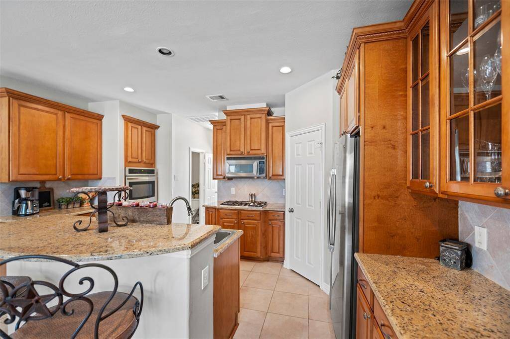This kitchen is sure to be the HUB of the home!  It offers lots of cabinets for storage, and pretty granite countertops for prep space or rolling out cookies for the holidays!  And we love the added touch of a few glass cabinets for display!