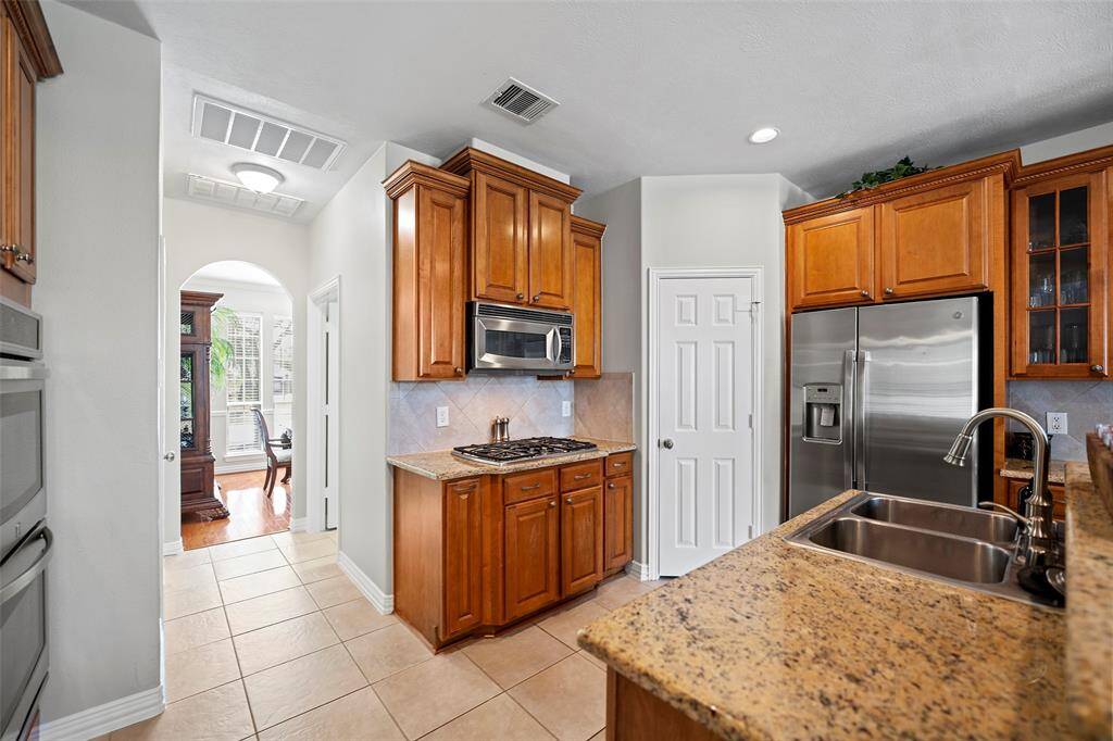 This kitchen features stainless steel appliances including double ovens, one being convection, and a gas cooktop!