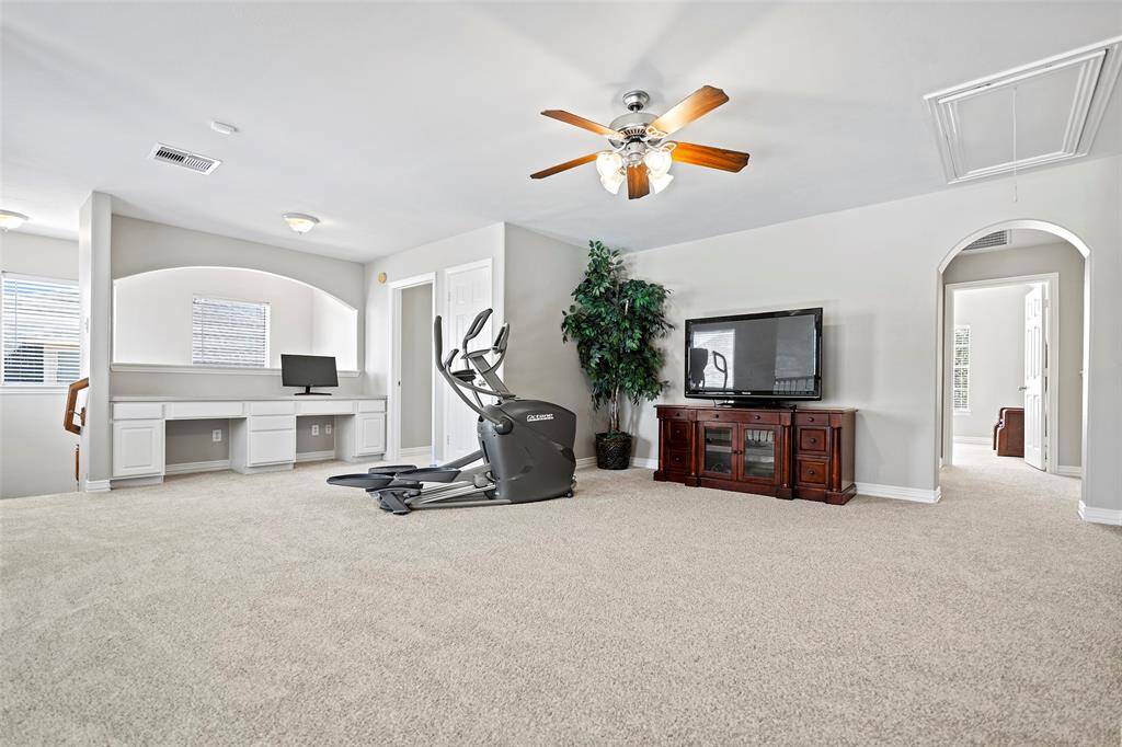 Venture upstairs and you will find this wonderfully spacious game room area complete with custom built-in desks featuring cabinets and drawers!