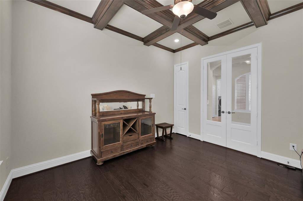 Beautiful French doors boast the elegance of this grand space for your office/study and as shown its plenty of room. Enjoy the architectural wood beams and notice the small storage closet too.