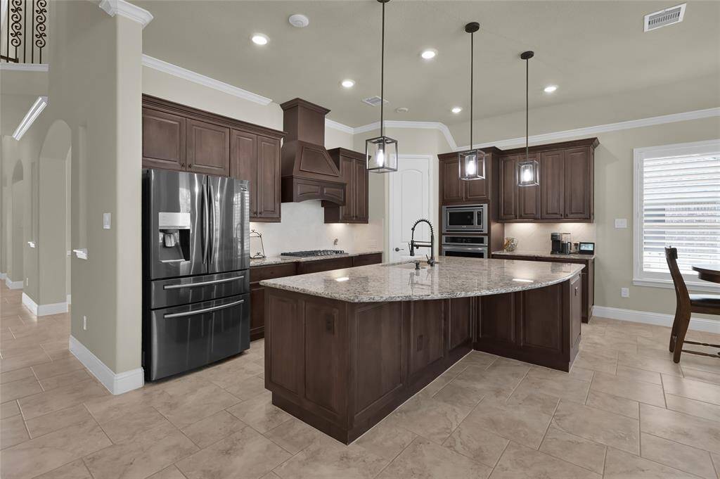 Equipped with modern cabinetry, an oversized island sleek backsplash and counterspace-this kitchen is an entertainers dream!