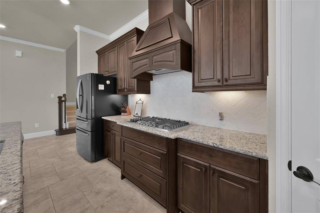 Deep rich wood, soft closing cabinets which also includes cabinet pan drawer storage under the stainless gas stove.