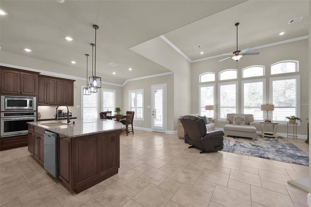 So easy for being in the kitchen and still being able to keep a watchful eye on outdoor activities. LOVE all the beautiful natural lighting and the customized shutters throughout the home!