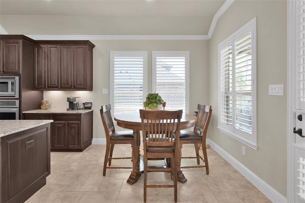 The breakfast room is ideal for full sized table of most any size and features easy to care tile floors, designer neutral paint, multiple bright windows with shutters and beautiful crown molding. What a way to come together for family meals!
