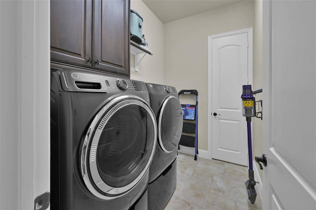 Discover the practicality of this well-appointed utility room, complete with direct access to the Primary Suite and garage access. This space is efficiently designed to accommodate washer, dryer, refrigerator and ample storage solutions. (washer & dryer available to stay with the home)