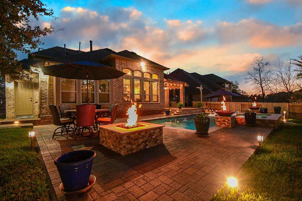 The evening glow this backyard captures is PRICELESS!! Firepit and fire bowls surrounding the pool along with all the great landscape lighting makes this backyard a TRUE backyard oasis!