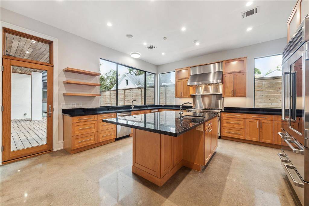 Loggia access from the kitchen makes hosting easy.  Despite the elegant, minimalist lines of the kitchen, there is ample storage with upper lit glass front cabinets and island cabinets.  Note the second prep sink on the island.  The cabinets are soft closing drawers and feature both lit glass uppers and under-cabinet lighting.