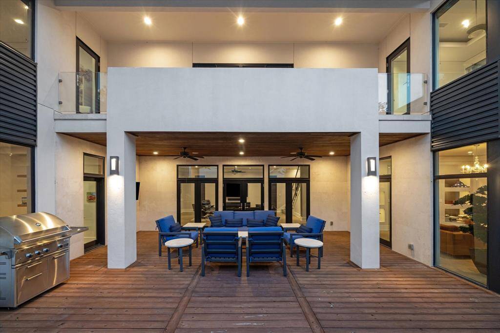 The beautiful loggia connects the kitchen on the left to the sitting room on the right.  The low maintenance stucco, steel siding accents and stained wood on the deck and ceiling offer a chic retreat.