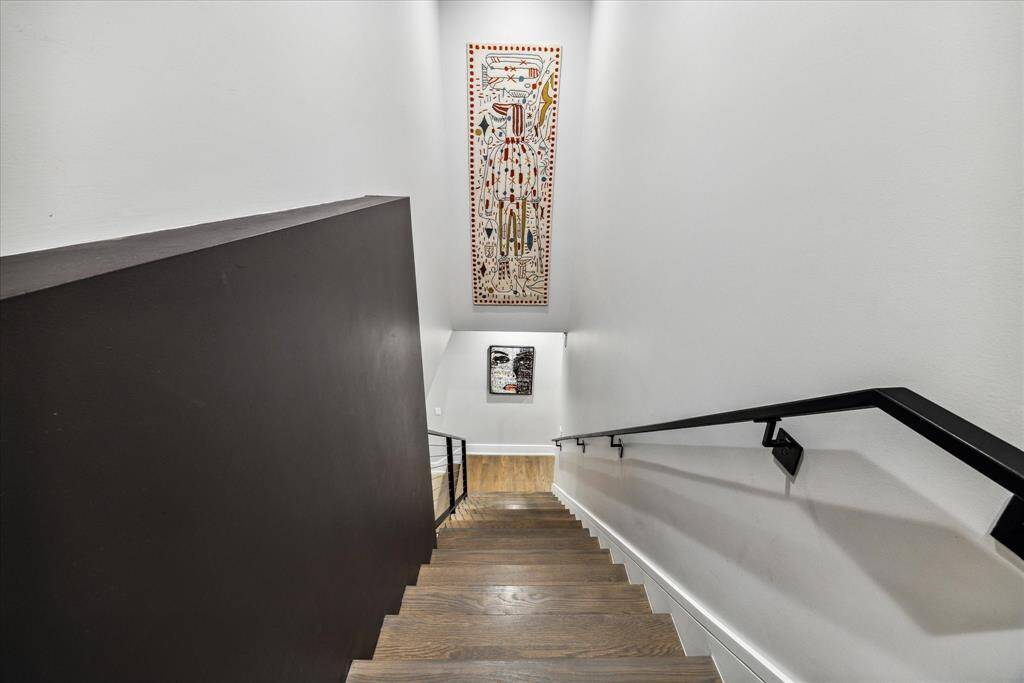 The descent of the main staircase from the primary suite is perfect to display and enjoy your favorite art every day.  Note the beautiful color and grain of the recently re-finished oil waxed oak floors.