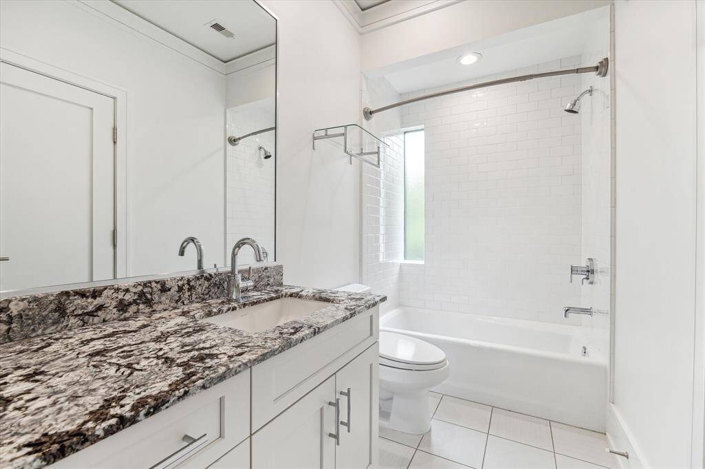 This secondary bathroom features natural light, beautiful fixtures and timeless finishes, including framed mirror, beautiful granite and shaker cabinetry.