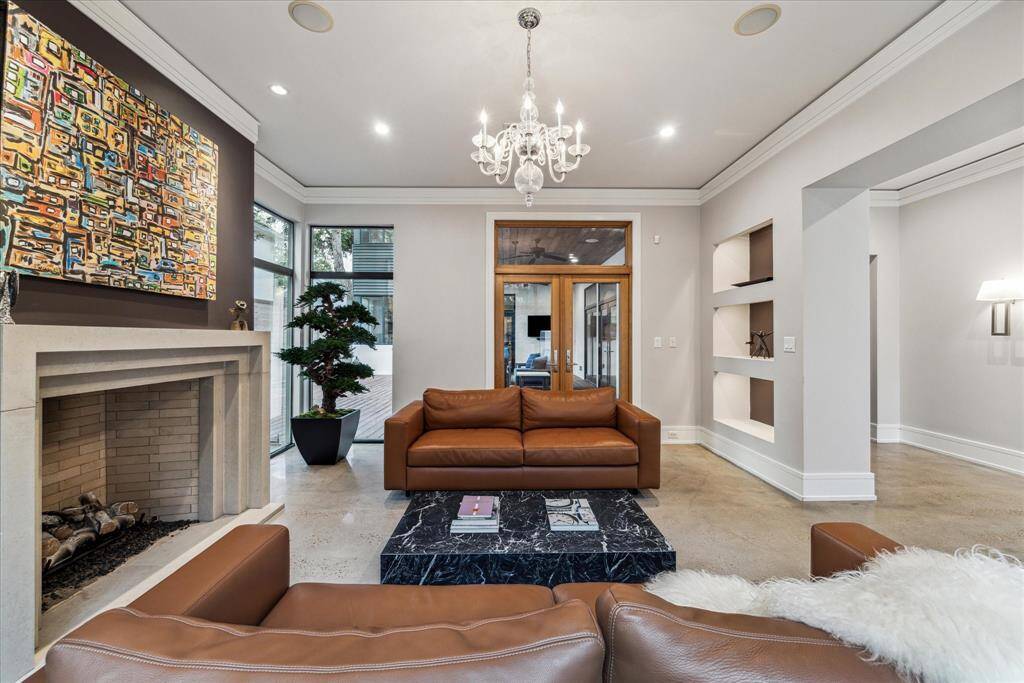 This room features the oversized gas log fireplace and access to the loggia.  Note the offset crown moulding not attached to the ceiling, here and throughout the house, providing architectural interest and practicality.  The sitting room has its own set of built-in speakers for a separate zone on the Control4 amplifier, included with the sale.