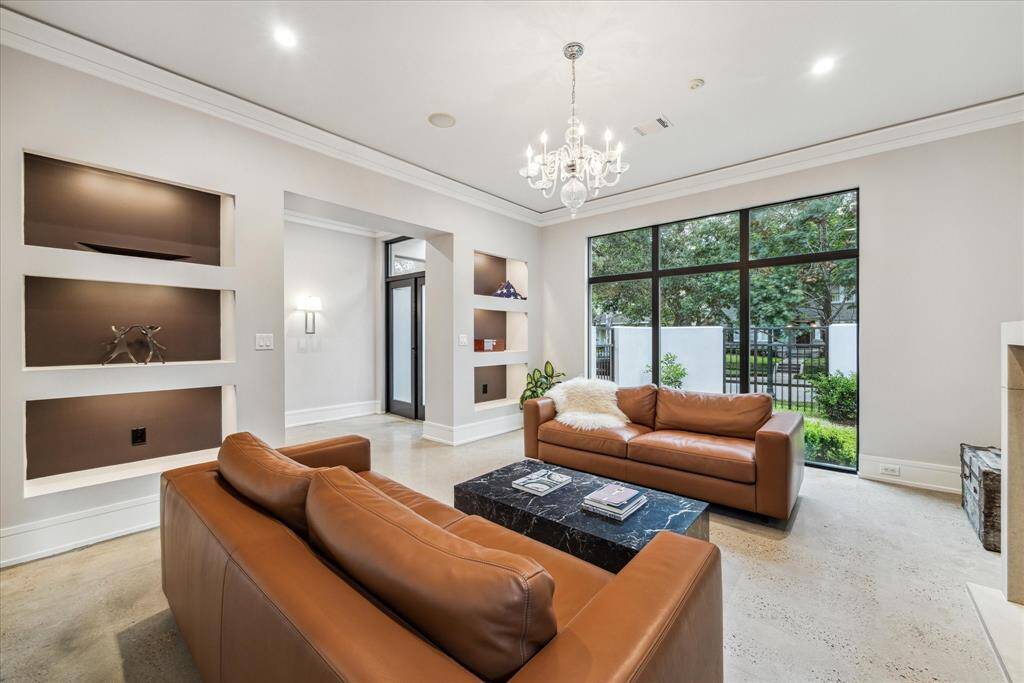 The stylish built-in display cabinets/book nooks offer and alternate use of this room as a library. The front windows flood the room with light and offer a view of the entry and neighbors on the front sidewalk through the wall's iron fence inserts.