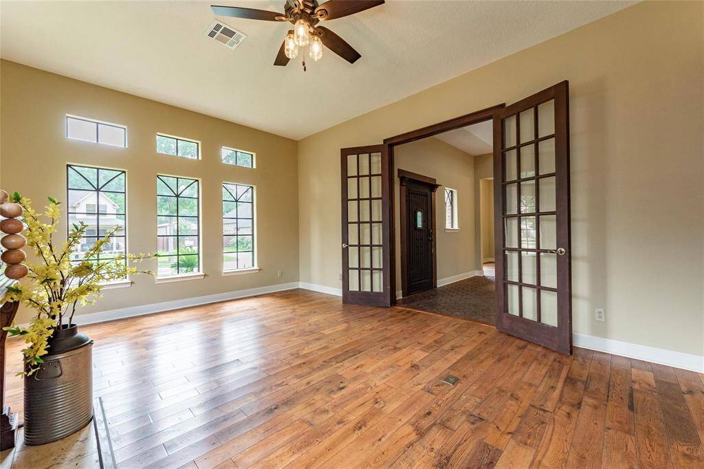Beautiful home-office or formal living area with luxury vinyl plank flooring, large windows, high ceilings and double French doors.