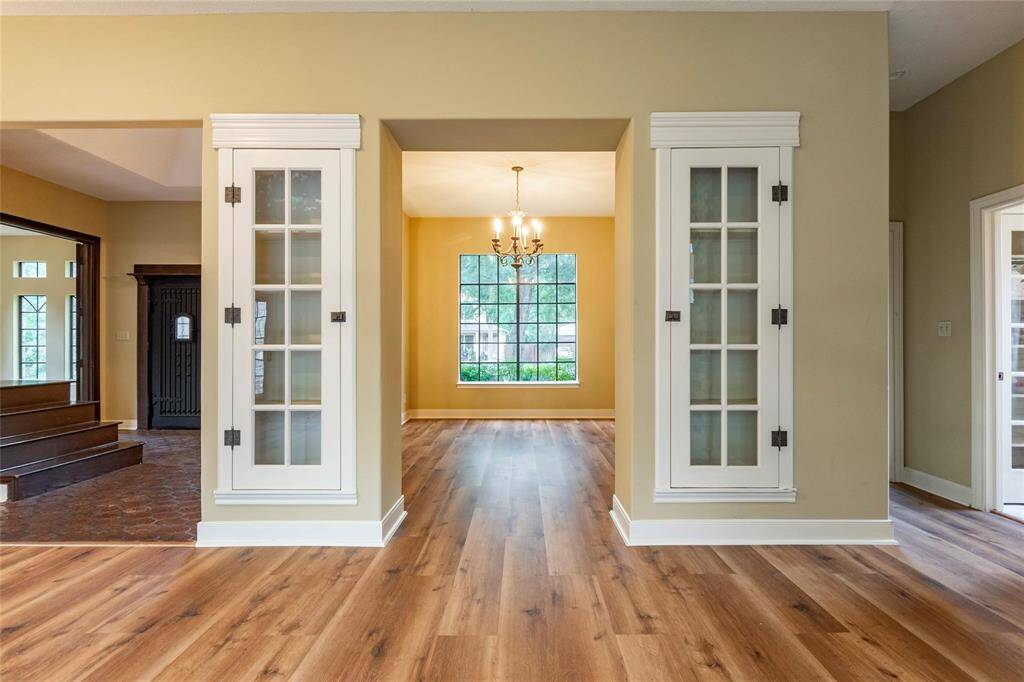 Open concept formal dining room accented by french glass door display cabinets.