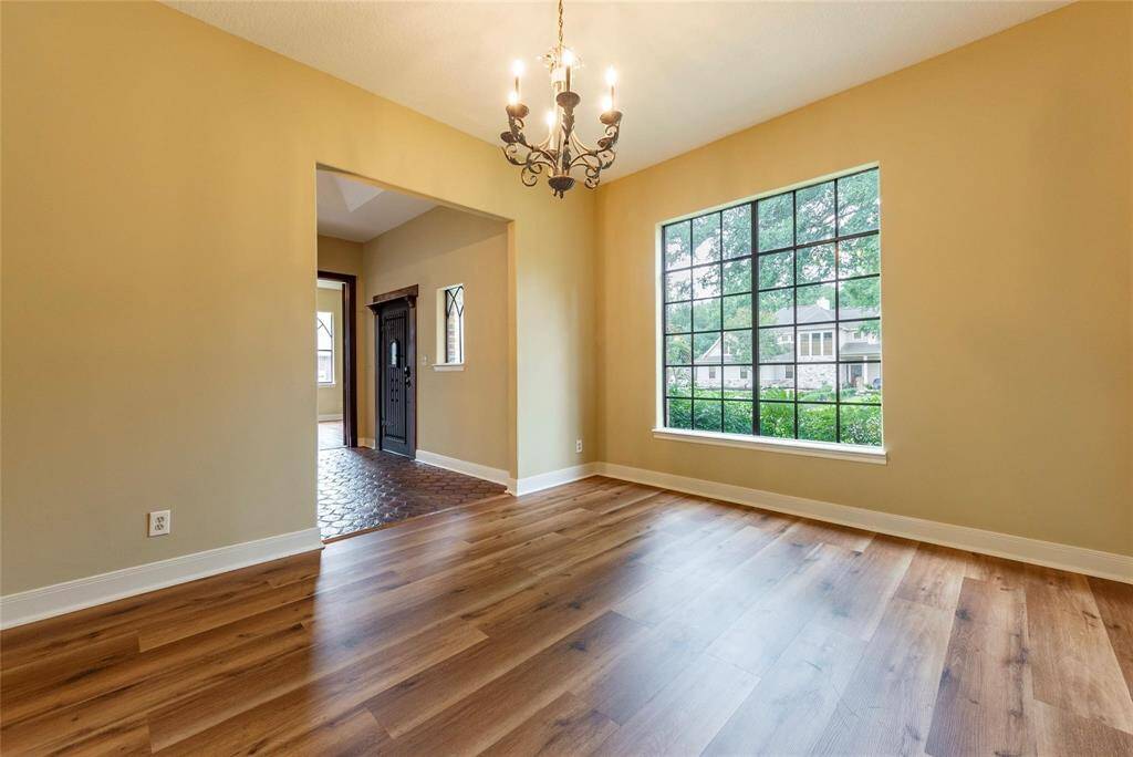Another view of the formal dining room with new luxury vinyl plank flooring and high ceilings.