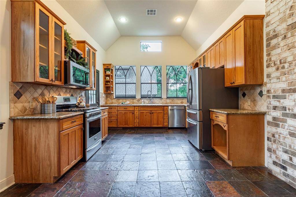 Charming designer kitchen with high ceilings, recessed can lighting, solid wood cabinets and gorgeous granite.
