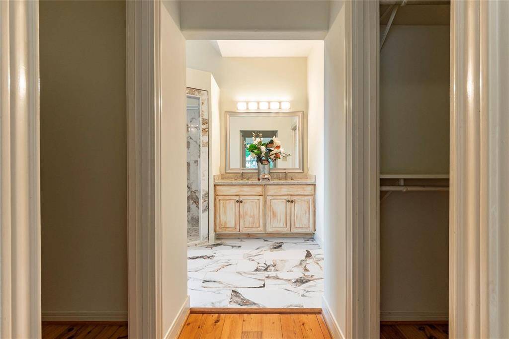 Direct access to the primary bathroom with his/her walk-in closets featuring wood floors.