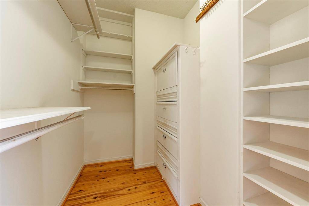 One of two walk in closets with wood floors, ample storage and built ins.