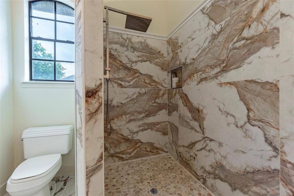 Full tiled walk-in shower with upscale shower fixture.