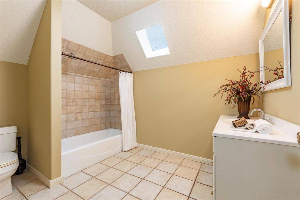 Full 3rd bath on the 2nd floor with tile flooring and shower tub combination.
