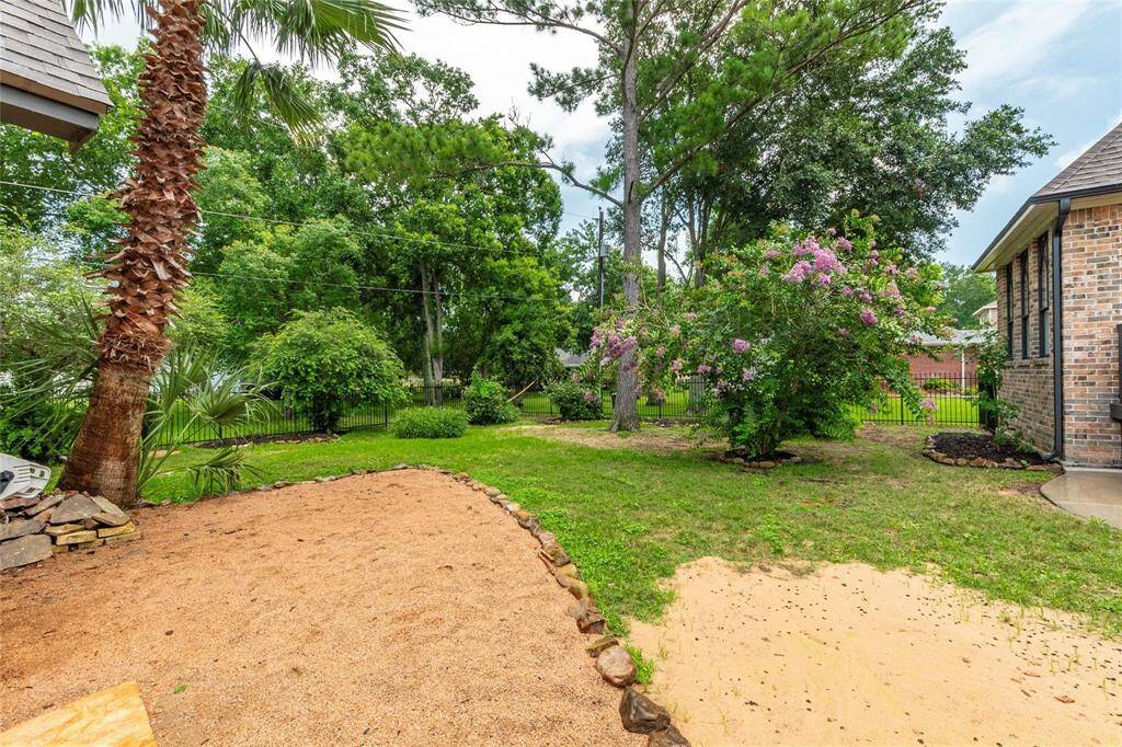 Large backyard with mature trees and landscaping throughout.
