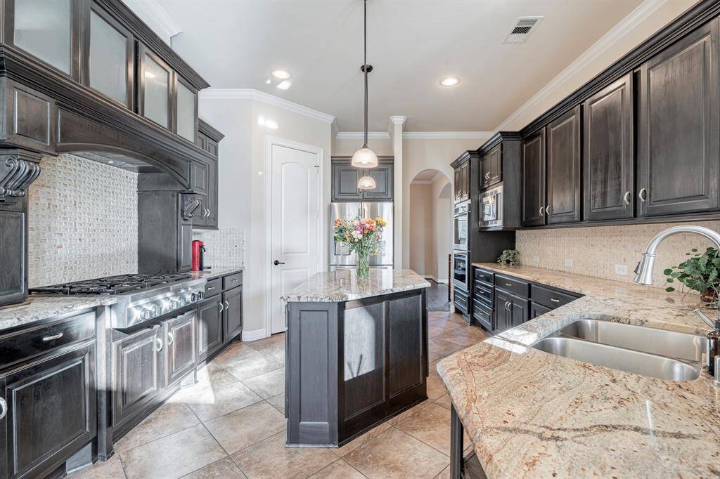 Complete with a stainless-steel 6 Burner Gas Stove, Custom cabinetry, Elegant trim, rustic, and custom vent hood