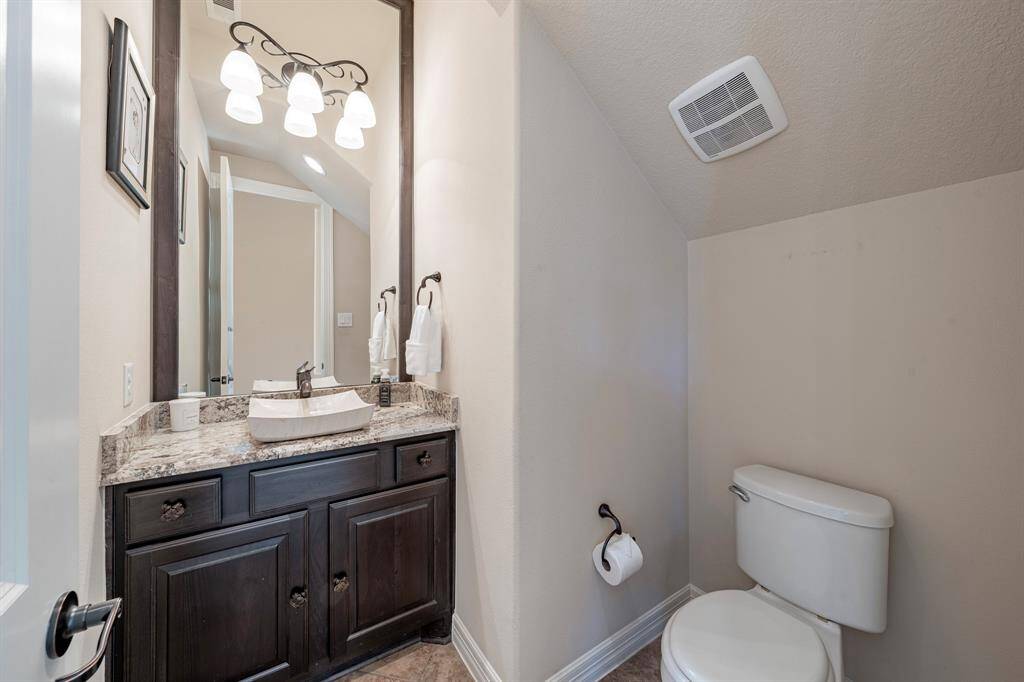 Powder bath is spacious with Custom cabinetry, updated fixtures, custom mirror and lighting