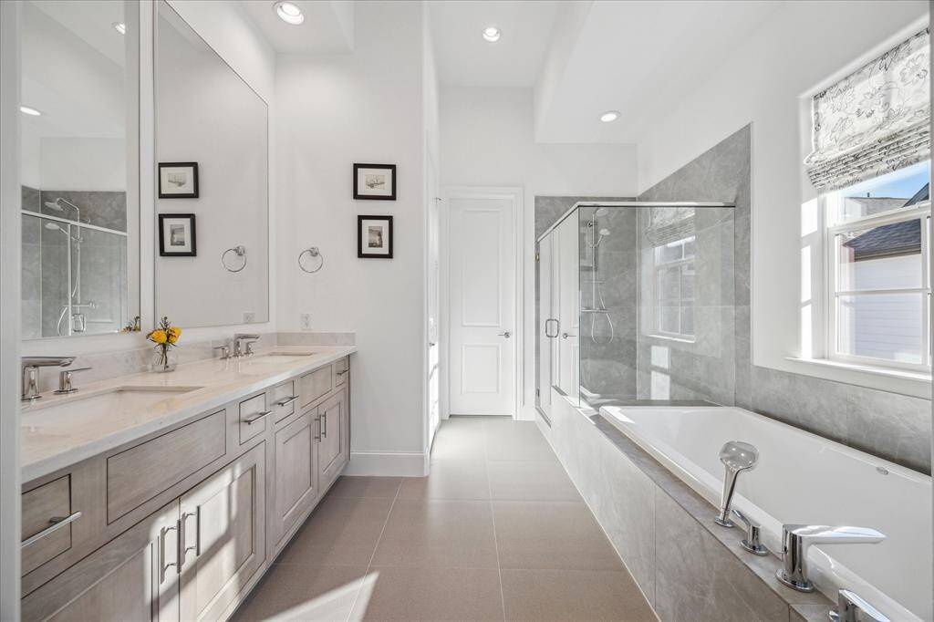The primary bathroom is elegant and spa-like with a neutral and soothing palette.