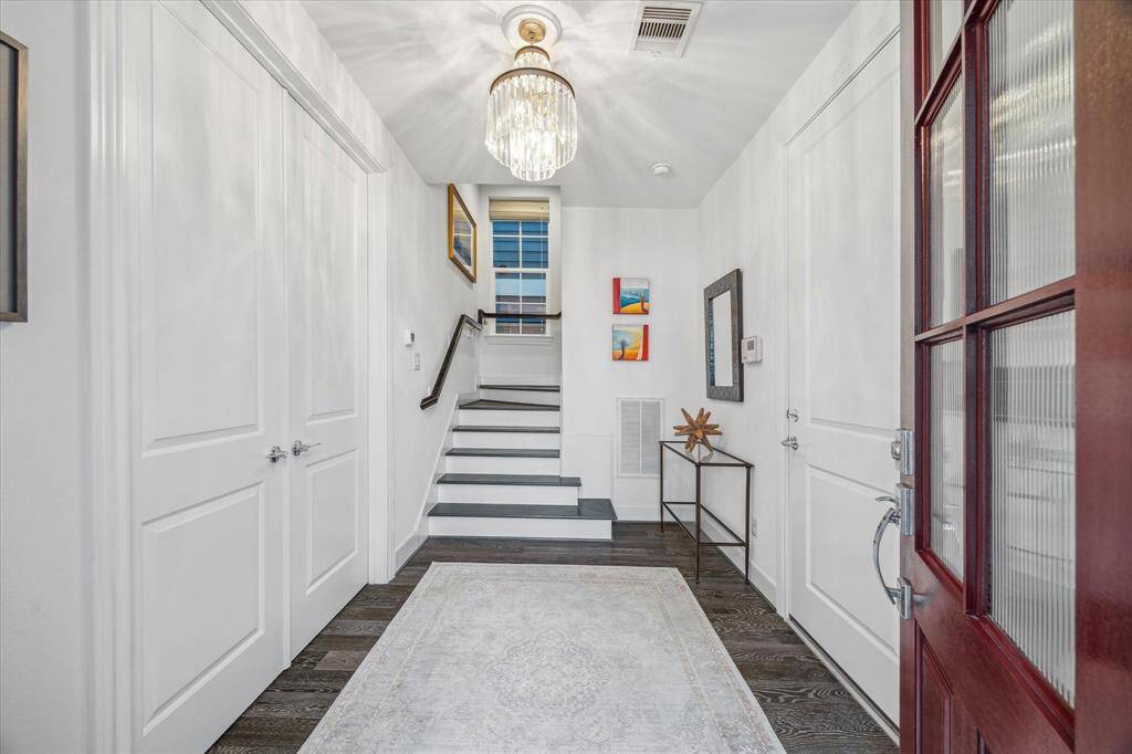 Enjoy greeting your guests in the formal entryway. A large bedroom with ensuite bathroom is through the double doors on the left, and the entrance to the garage is to the right.