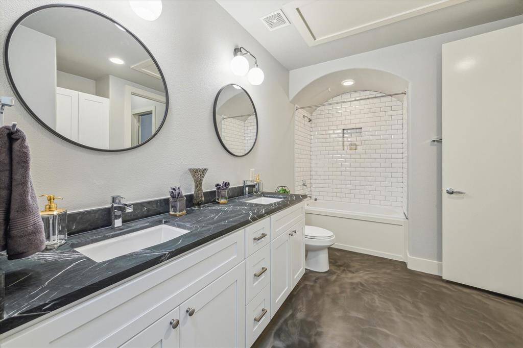 The large primary bathroom features marble countertops, dual sinks, shower/bathtub comb, under sink storage, and walk-in closet.