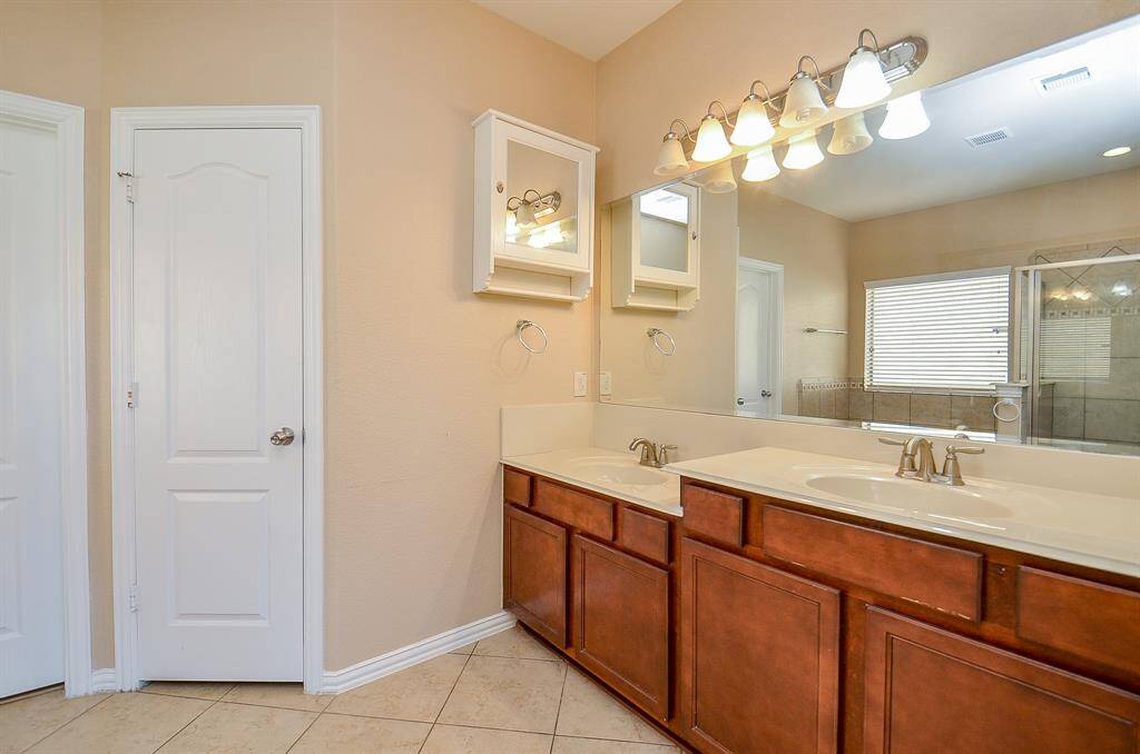 This elegant primary bathroom features dual sinks and a spacious vanity mirror.