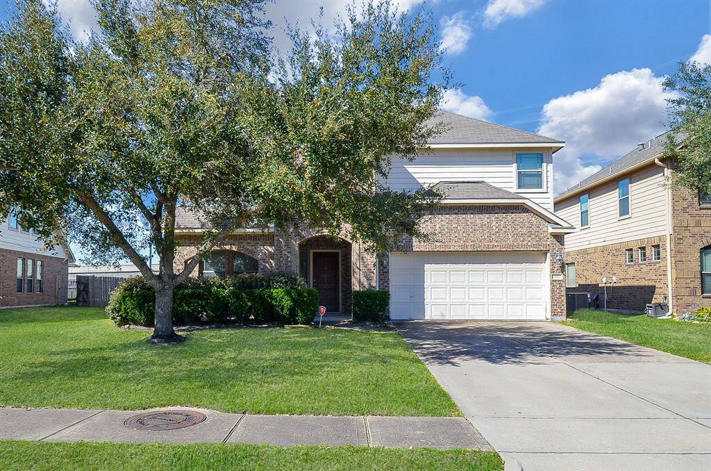 This stunning two-story home features charming brickwork, a spacious driveway, and lush landscaping. Perfect for modern living.