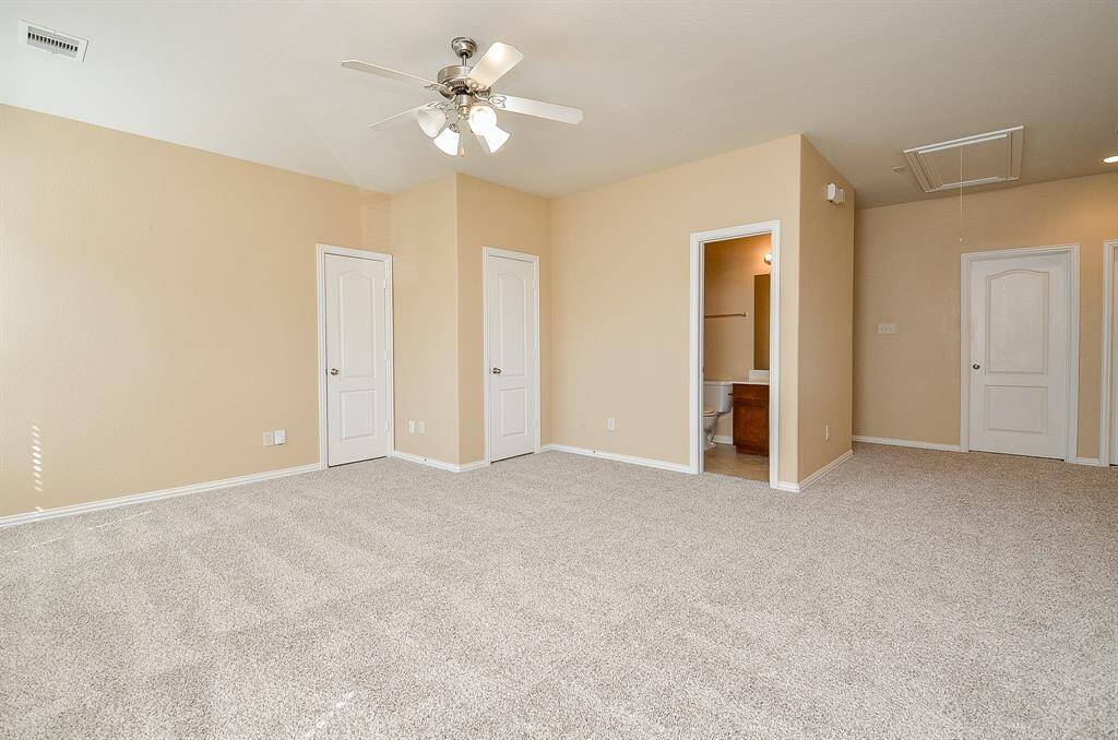 Spacious bedroom with plush carpeting and a private en-suite bathroom.