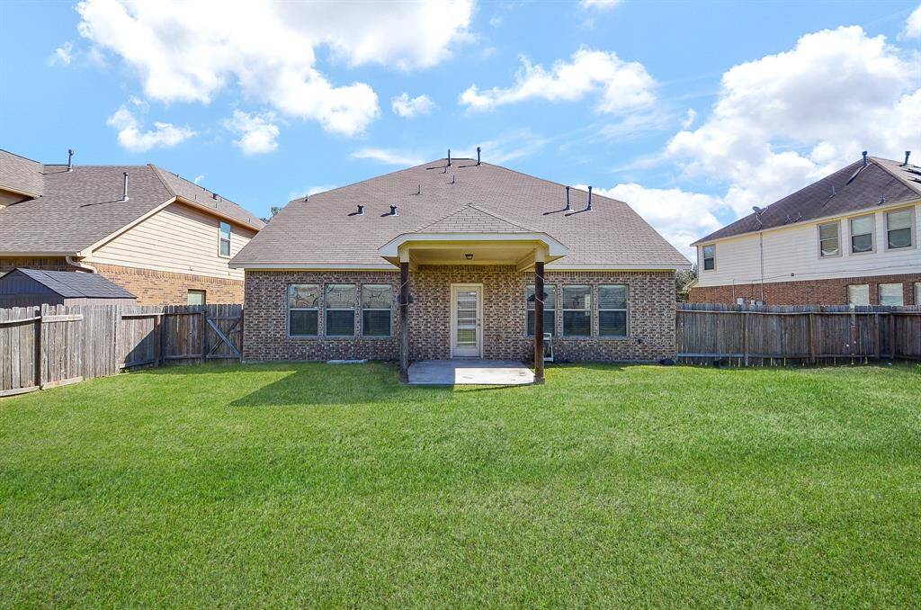 Expansive backyard with a covered patio, perfect for outdoor activities.