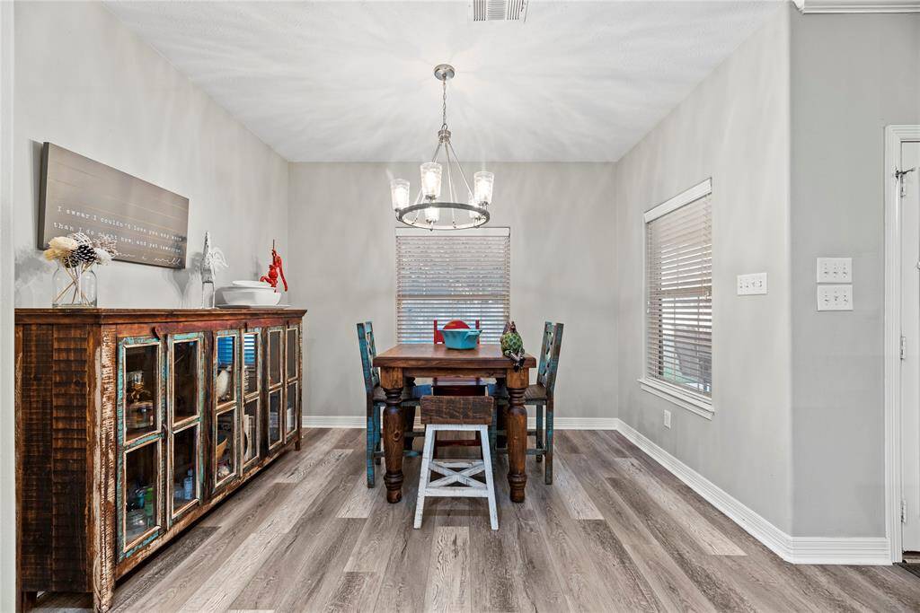 The breakfast room is ideal for a full-sized table and features an overhead chandelier, easy access to the kitchen and large bright windows giving picturesque views of the backyard.
