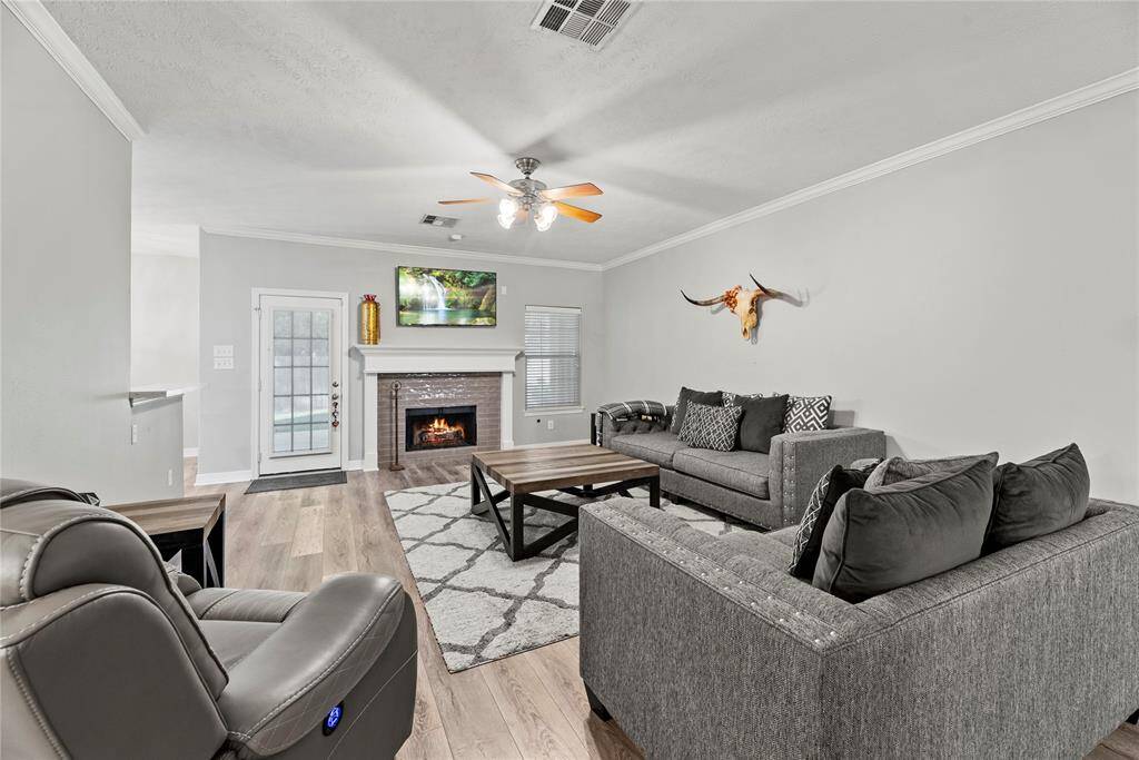Now into the living space. This is such a comfortable space to relax, visit and just be with family. Sleek wood-like vinyl planks, cozy center fireplace, tons of charm.