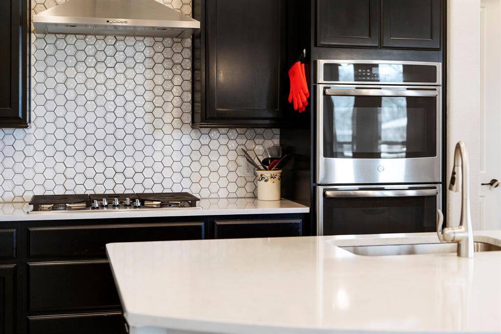 Gorgeous white quartz countertops with hex tile backsplash.