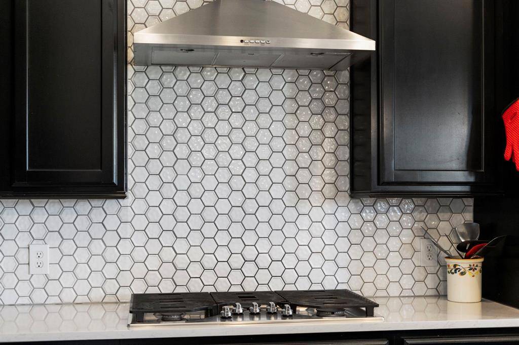 Stainless steel gas cooktop and vent hood.